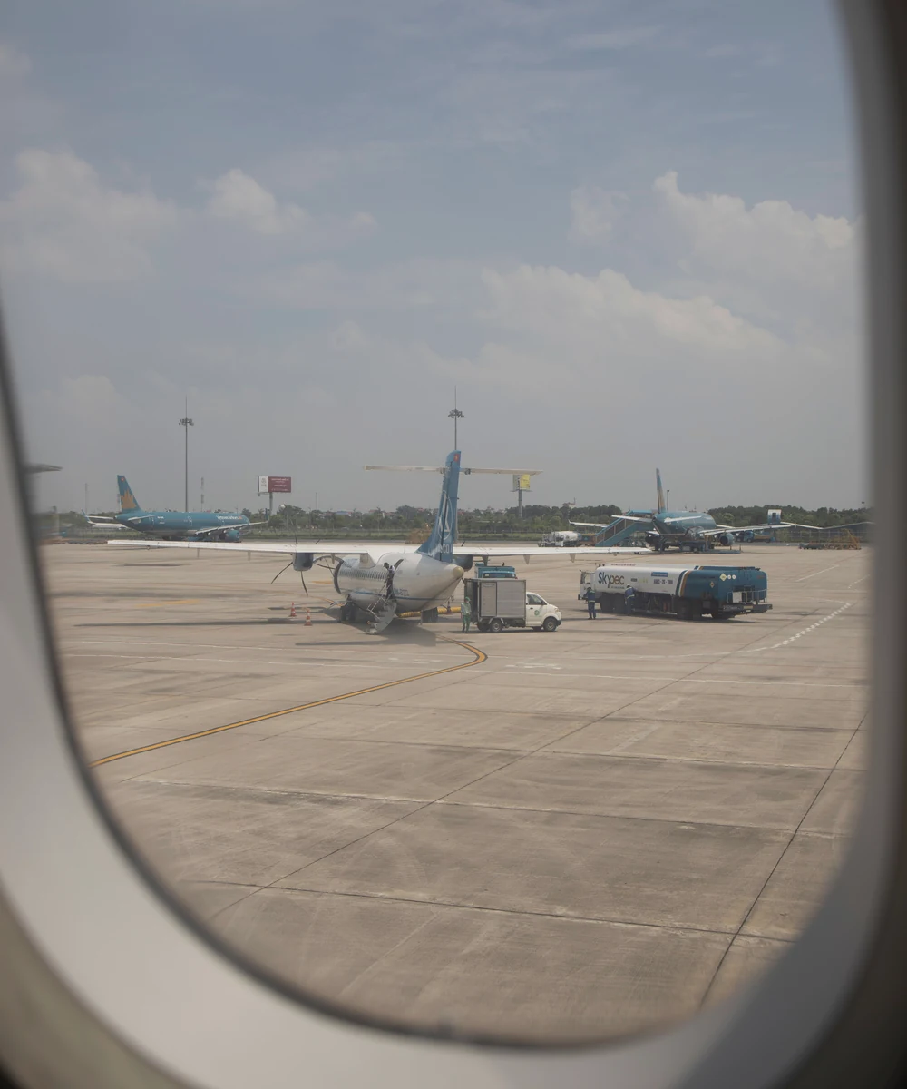 View of aircraft on an airport apron through a passenger window