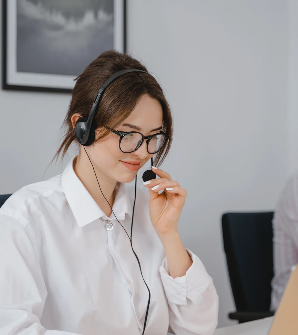 Female customer support representative wearing a headset in a call center